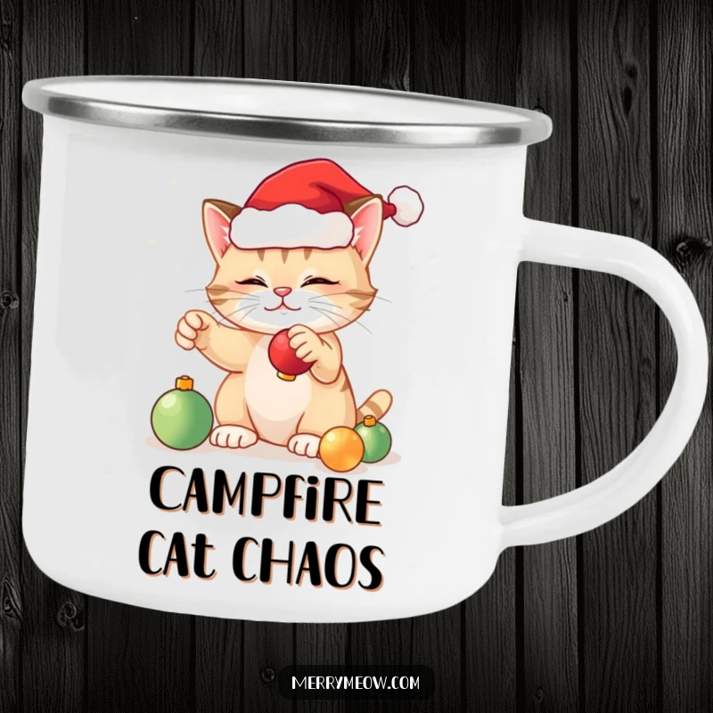 Funny festive cat camping mug showing a cat in a Santa hat batting at ornaments, designed for cheerful holiday outings.