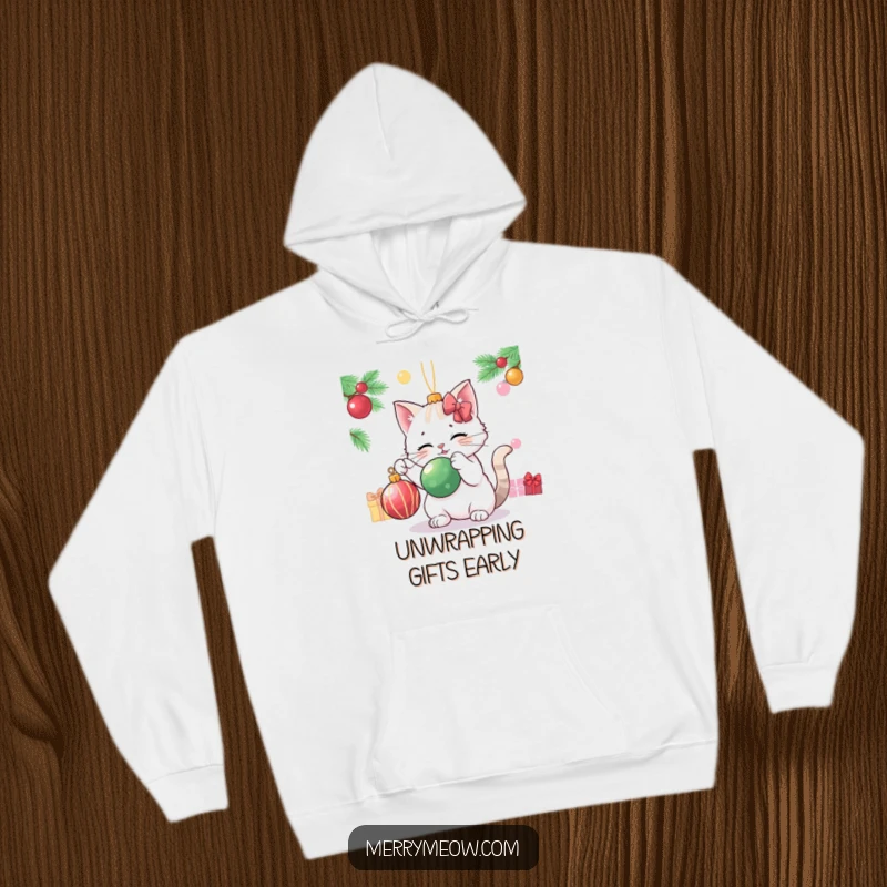 Funny cat character engaging in playful batting of a Christmas ornament, featured on a warm and humorous hoodie.