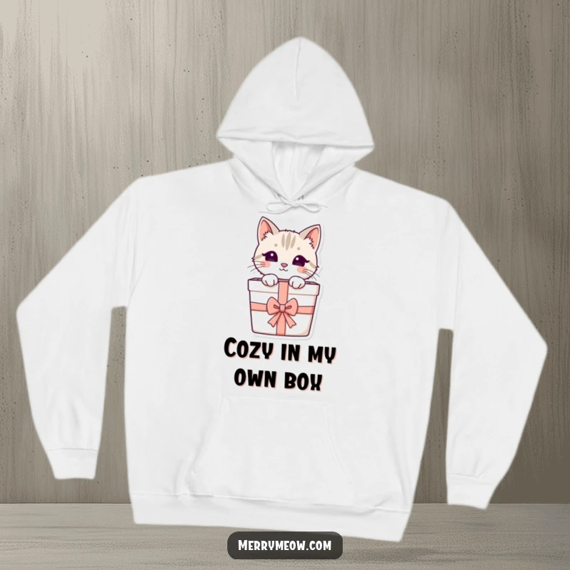 Funny hoodie print of an adorable cat peeking from a decorated gift box, providing cozy comfort and a touch of playful mystery.