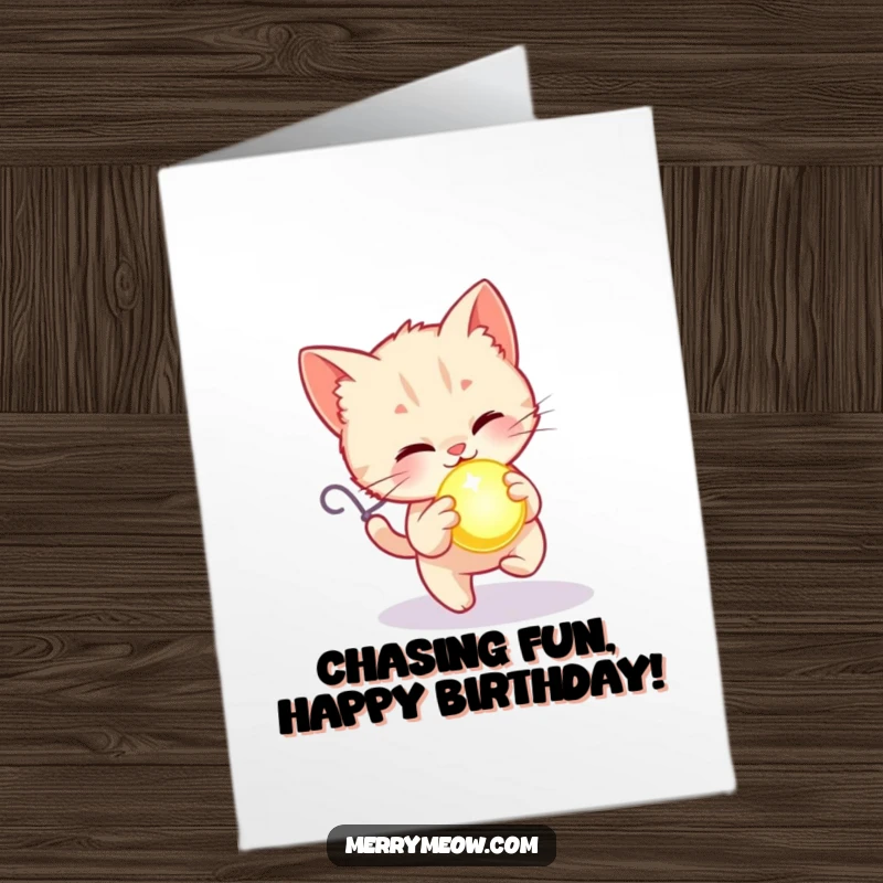 Free Printable Kitten Birthday Card: A playful kitten happily chases a brightly glowing holiday ornament.