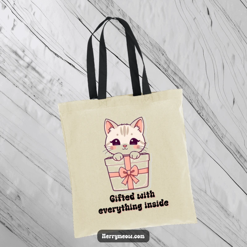 Funny tote bag featuring a cute cat peeking from a present with a ribbon, perfect for grocery runs and cat-themed outings.